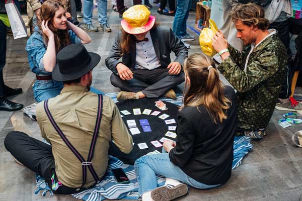 Menschen sitzen auf dem Boden und spielen mit Karten